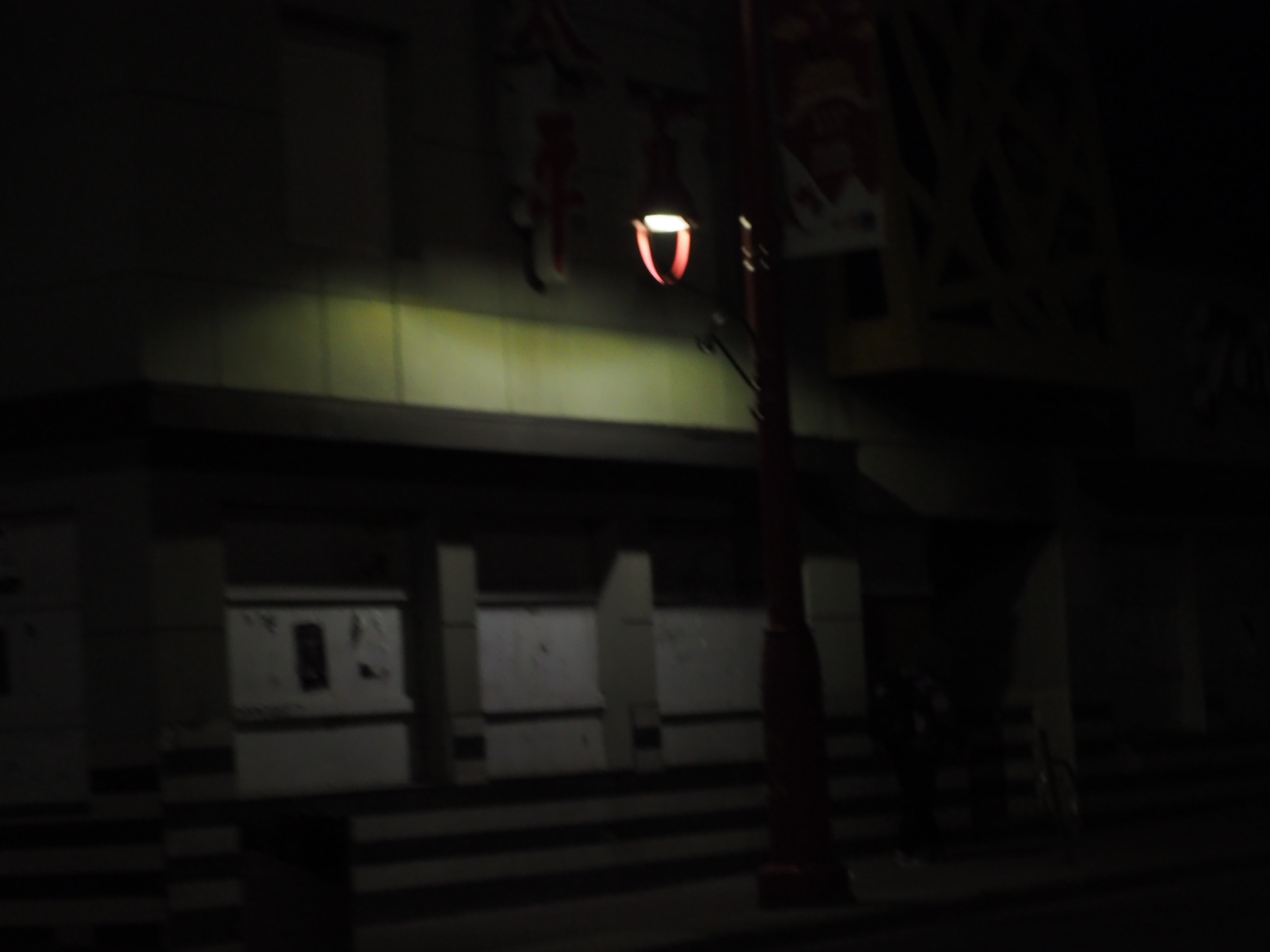 dim building entrance with a small shield-shaped sign at night in edmonton