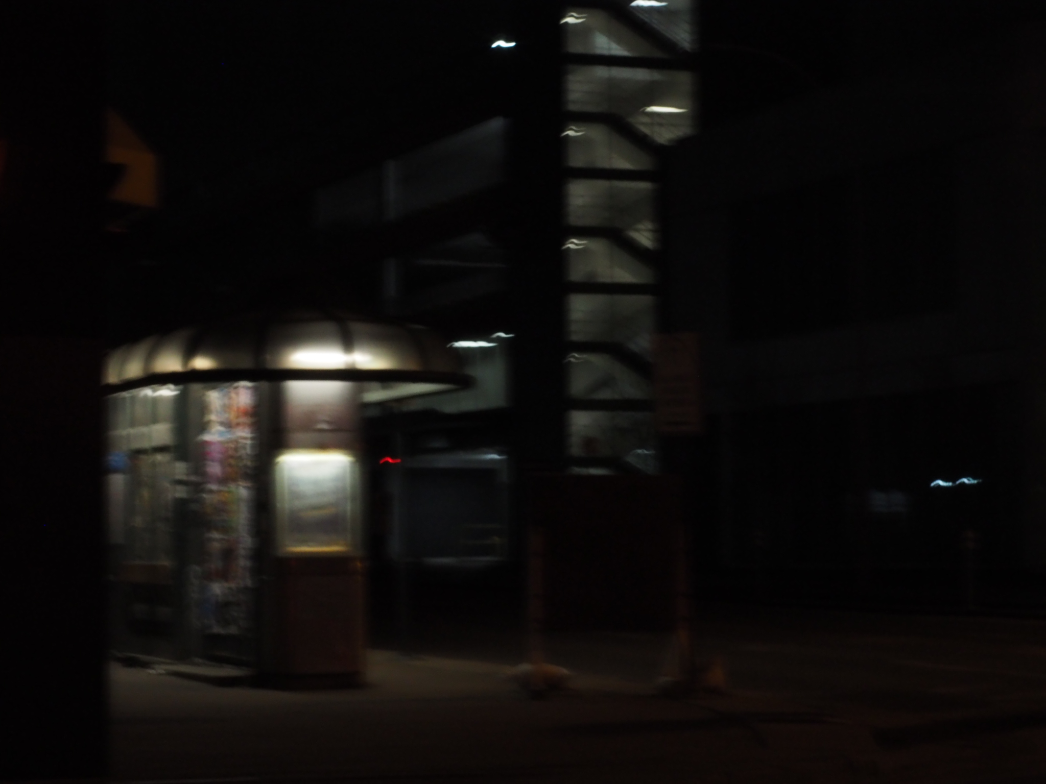 brightly lit kiosk or storefront entrance breaking through a dark edmonton street at night