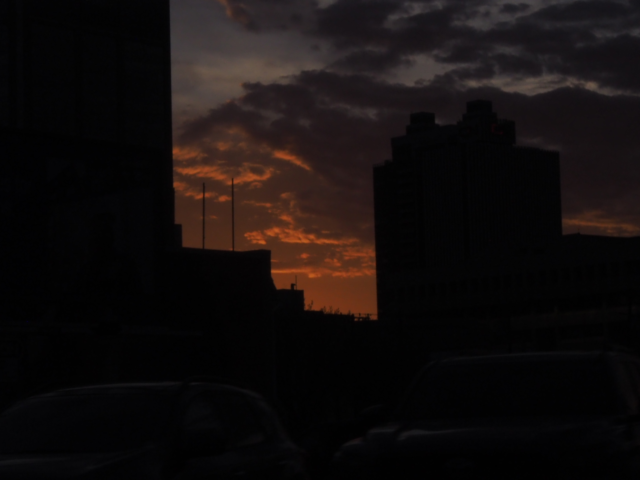 dark building silhouette against an orange and violet sunset sky in edmonton