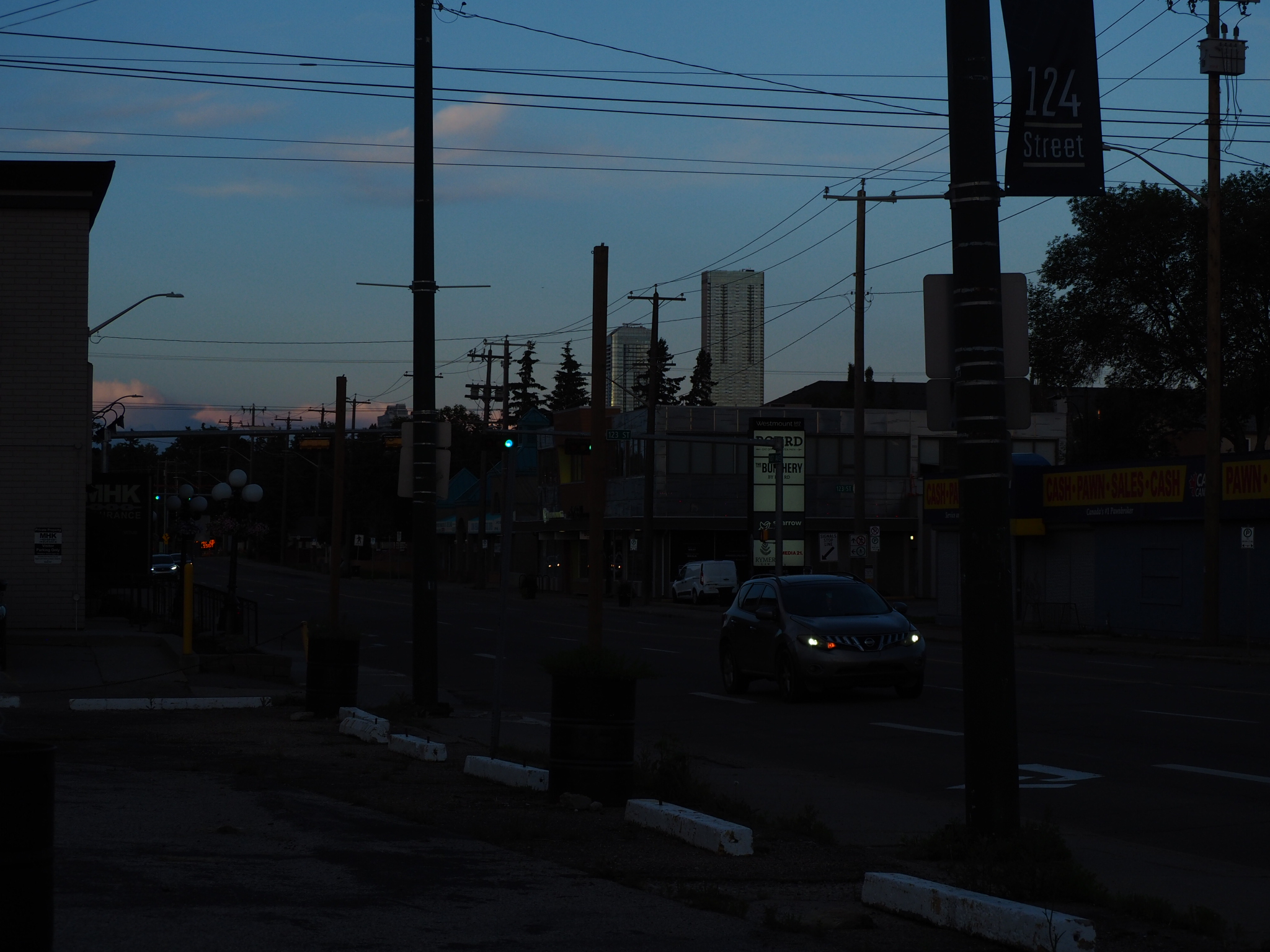 edmonton street with utility lines, traffic, and distant towers at blue hour