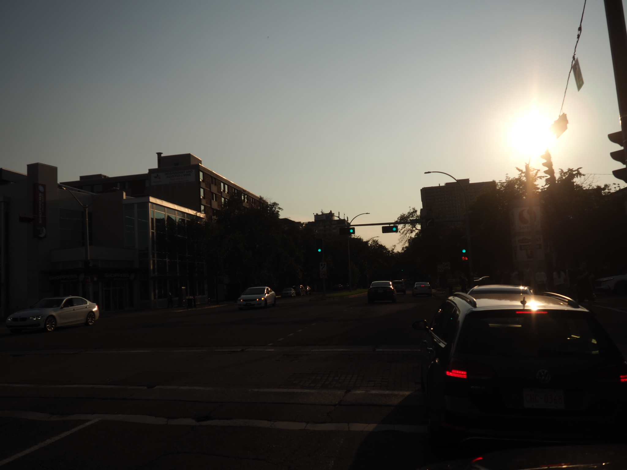 cars and traffic lights silhouetted against sunset on an edmonton street