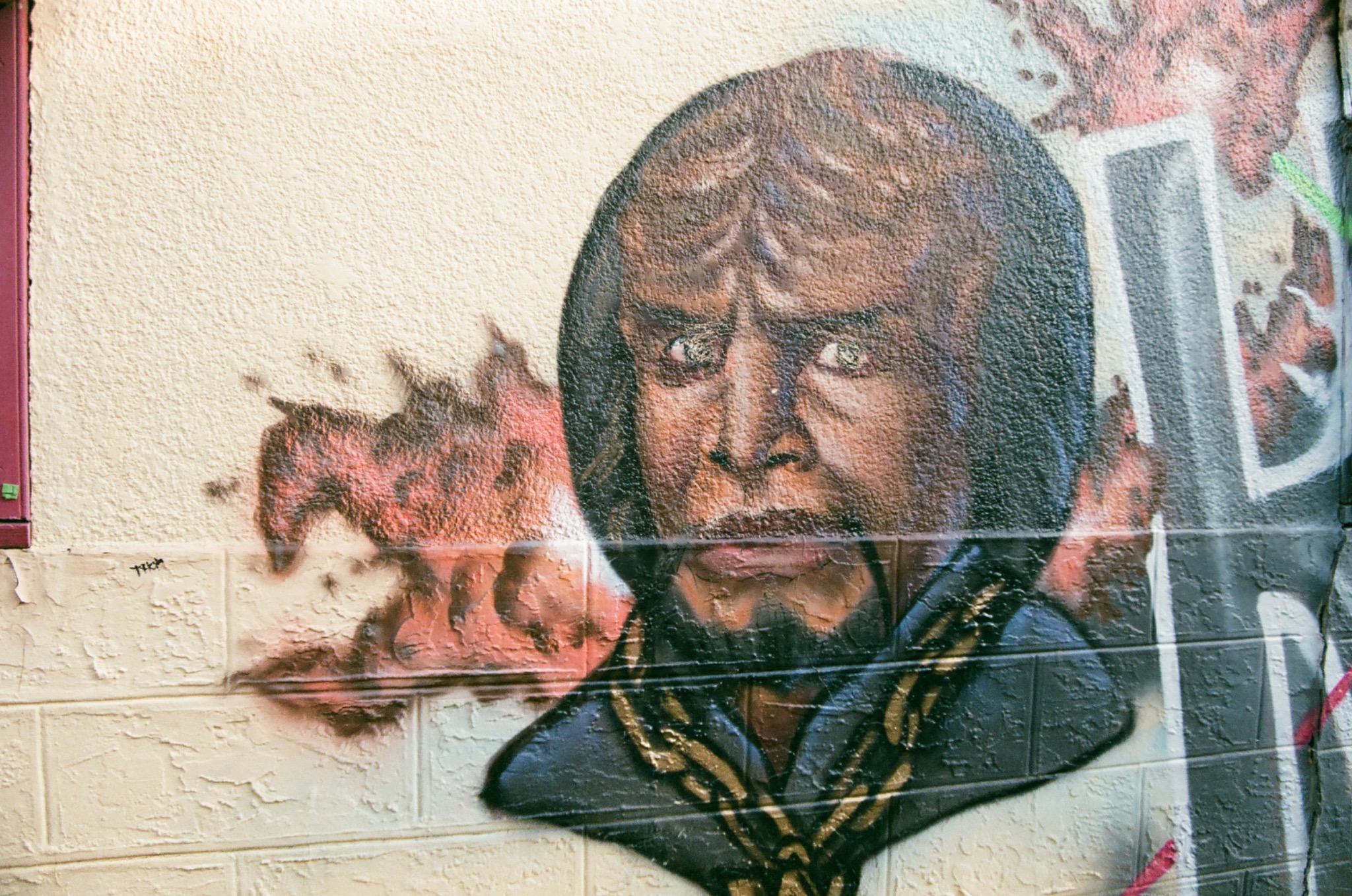 graffiti of a klingon warrior from star trek on a textured brick wall