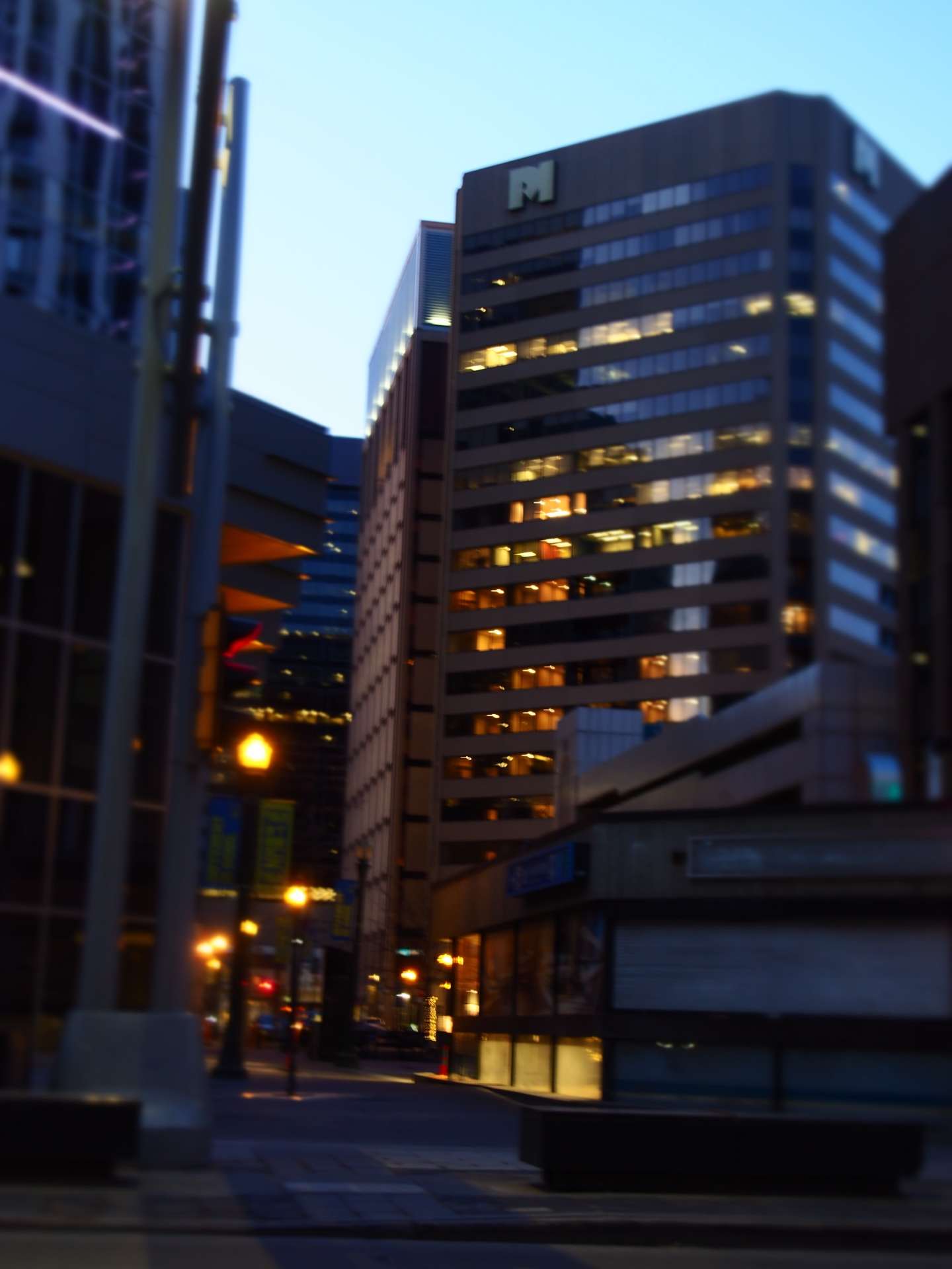 illuminated office windows above a dark downtown street in edmonton at dusk